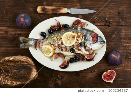 Delicious whole dorado fish baked with figs. Delicious whole dorado fish baked with figs. 109234387