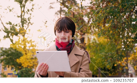 Woman checks work of employees on tablet going to meeting with boss in park 109235707