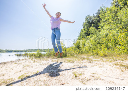Joyful Leap: Carefree Moment by the Lake Joyful Leap: Carefree Moment by the Lake 109236147