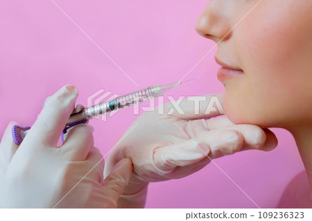 sensual female lips, procedure lip augmentation. Syringe near womans mouth, injections for increase lips shape 109236323