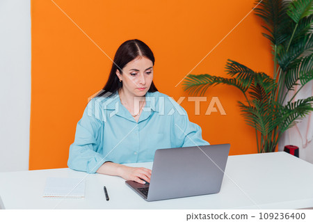 Woman in office working on laptop 109236400
