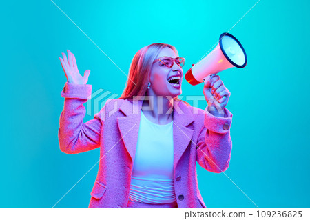 Portrait of young woman loudly screaming to loudspeaker about starting sales season against gradient background illuminated mixed colors neon light. Portrait of young woman loudly screaming to loudspeaker about starting sales season against gradient background illuminated mixed colors neon light. 109236825
