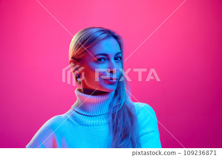 Close up portrait of young beautiful woman with smirk, suspicious looking at camera against gradient pink background. Concept of human emotions. 109236871