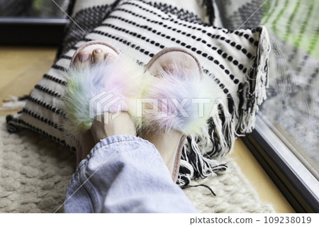 Woman's feet with a pink pedicure in colorful rainbow slippers 109238019