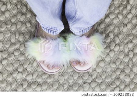 Woman's feet with a pink pedicure in colorful rainbow slippers 109238058