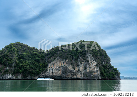 越南:一個人在奇岩怪石環繞的下龍灣劃著獨木舟,到達一個旅遊景點。 越南:一個人在奇岩怪石環繞的下龍灣劃著獨木舟,到達一個旅遊景點。 109238218