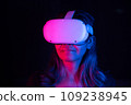 Young asian woman using at home Virtual Reality headset playing VR video games, neon pink blue light 109238945