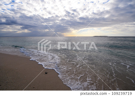 Shining waves crashing onto the sandy beach 109239719