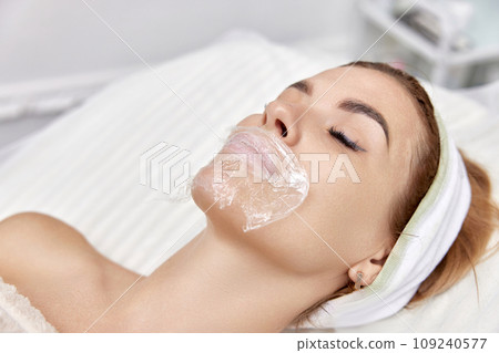woman with anesthetic cream on lips before injecting hyaluronic acid. Lip augmentation procedure woman with anesthetic cream on lips before injecting hyaluronic acid. Lip augmentation procedure 109240577