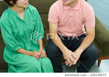 A man and a woman sitting on a sofa and talking A man and a woman sitting on a sofa and talking 109240675