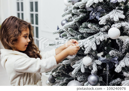 7-year-old girl at christmas tree with gifts and toys for new year 7-year-old girl at christmas tree with gifts and toys for new year 109240976