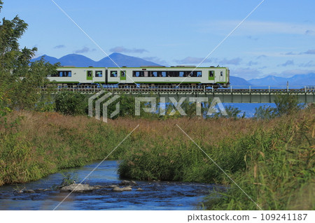 Hachiko Line Kiha 110 series diesel train crossing the Kannagawa River with Mt. Akagi in the background_Photo taken on November 11, 2023 109241187