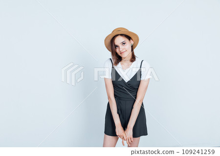 Portrait of a beautiful young woman in a black dress and hat 109241259