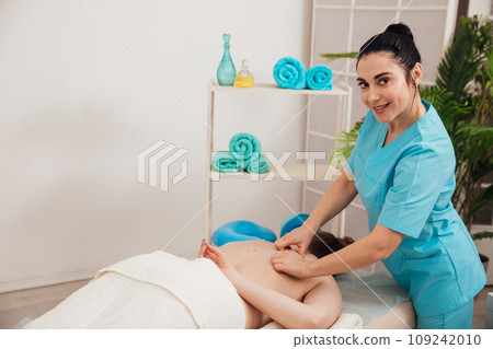 Beautiful woman enjoying a massage therapy Beautiful woman enjoying a massage therapy 109242010