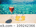Glass of pink wine and yellow sunglasses at the pool. 109242366