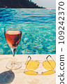 Glass of pink wine and yellow sunglasses at the pool. 109242370