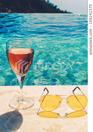Glass of pink wine and yellow sunglasses at the pool. 109242370