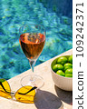Glass of pink wine and yellow sunglasses at the pool. 109242371