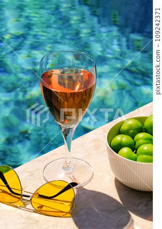 Glass of pink wine and yellow sunglasses at the pool. 109242371