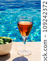 Glass of pink wine and yellow sunglasses at the pool. 109242372