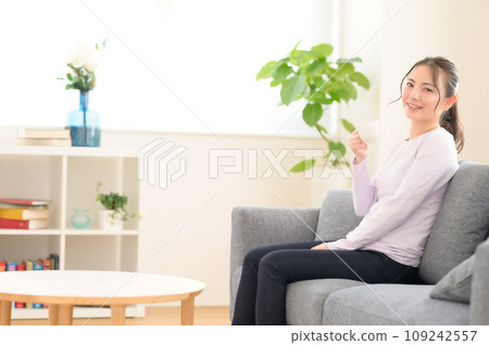 一個女人坐在沙發上和放鬆 109242557