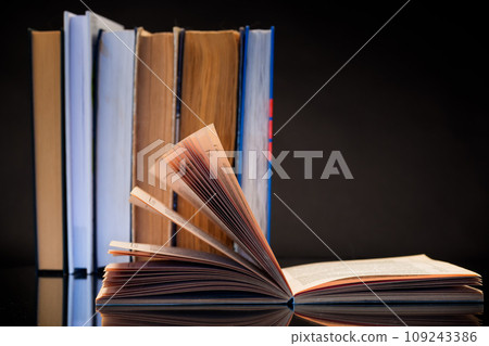 open book for reading and a stack of books 109243386
