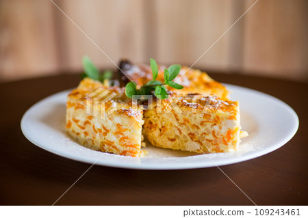 Cooked cottage cheese casserole with pieces of pumpkin inside. Cooked cottage cheese casserole with pieces of pumpkin inside. 109243461