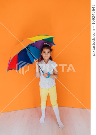 Little girl standing with colorful umbrella from the rain Little girl standing with colorful umbrella from the rain 109243643