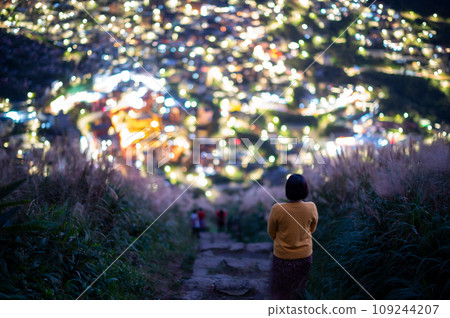 Overlooking the lively and colorful valley villages at night. Jiufen, Taiwan. 109244207