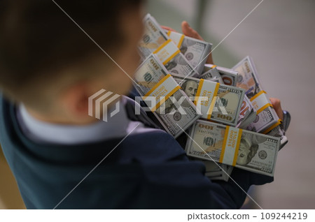 Banker holding in hands lot of packages with money closeup Banker holding in hands lot of packages with money closeup 109244219