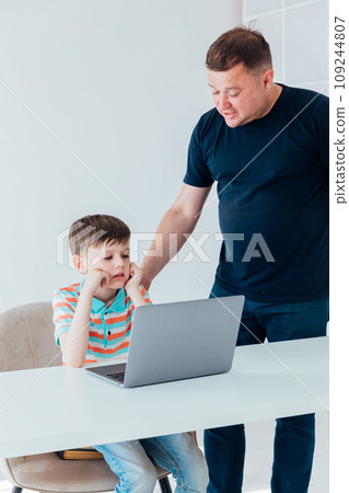 Men teaching boy on laptop in school classroom 109244807
