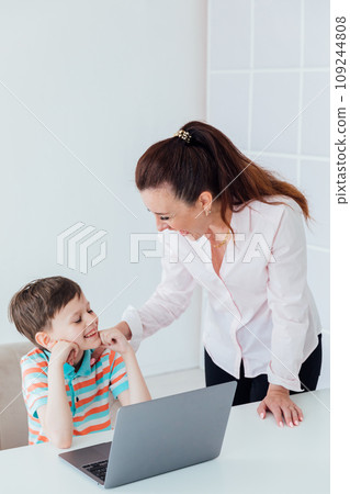 Woman teaching boy on laptop in school classroom 109244808