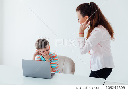 Woman teaching boy on laptop in school classroom 109244809