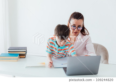 Woman with boy watching online laptop at desk at work in office 109244820