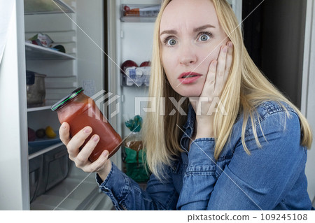 Woman reads instructions for food products at home. Checking labels on goods. Study of product compositions. Search Internet for descriptions of product gradients. Useful or harmful. Nutritionology 109245108