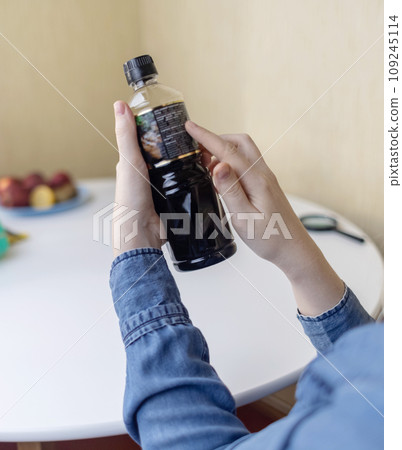 Woman reads instructions for food products at home. Checking labels on goods. Study of product compositions. Search Internet for descriptions of product gradients. Useful or harmful. Nutritionology 109245114