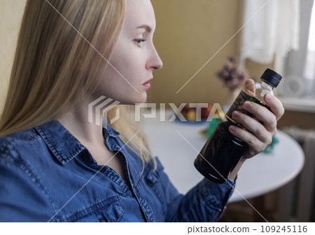 Woman reads instructions for food products at home. Checking labels on goods. Study of product compositions. Search Internet for descriptions of product gradients. Useful or harmful. Nutritionology 109245116