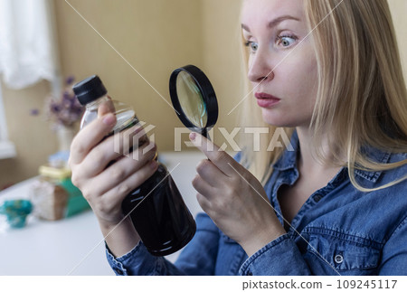 Woman reads instructions for food products at home. Checking labels on goods. Study of product compositions. Search Internet for descriptions of product gradients. Useful or harmful. Nutritionology 109245117