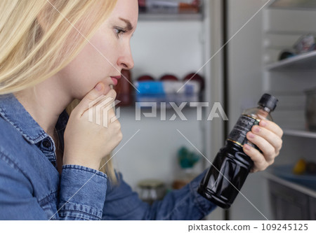 Woman reads instructions for food products at home. Checking labels on goods. Study of product compositions. Search Internet for descriptions of product gradients. Useful or harmful. Nutritionology 109245125