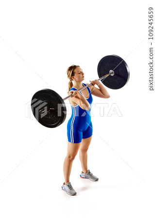 Athletic young girl with strong hands and body training, lifting heavy weight, barbell against white background 109245659
