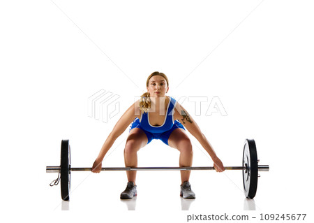 Athletic young girl with strong hands and body training, lifting heavy weight, barbell against white background 109245677