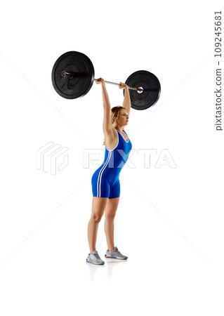 Competition. Full-length of young woman in sportswear, lifting heavy barbell against white background Competition. Full-length of young woman in sportswear, lifting heavy barbell against white background 109245681