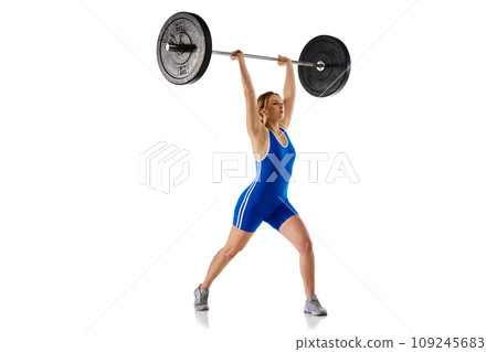 Young girl with fit strong body, athlete training, lifting heavy weights, barbell against white background Young girl with fit strong body, athlete training, lifting heavy weights, barbell against white background 109245683
