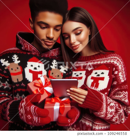 funny sweet young loving couple dressed print pullover buying christmas gifts typing modern gadget on red color background funny sweet young loving couple dressed print pullover buying christmas gifts typing modern gadget on red color background 109246558
