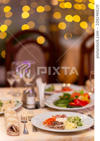 Served festive table with snacks, glasses, glasses, cutlery and napkins for a banquet Served festive table with snacks, glasses, glasses, cutlery and napkins for a banquet 109246620