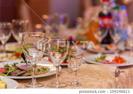 Served festive table with snacks, glasses, glasses, cutlery and napkins for a banquet Served festive table with snacks, glasses, glasses, cutlery and napkins for a banquet 109246621