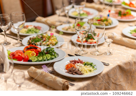 Served festive table with snacks, glasses, glasses, cutlery and napkins for a banquet Served festive table with snacks, glasses, glasses, cutlery and napkins for a banquet 109246662