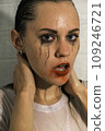 Portrait of a young girl looking at camera with dripping makeup standing in the shower. Vertical Shot 109246721