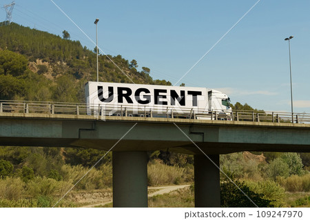 A truck is driving across the bridge, with the inscription on the trailer - Urgent. 109247970