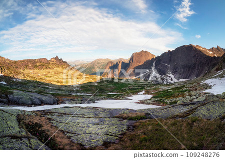 Foggy mountain view from cliff at very high altitude. Scenic alpine landscape with beautiful sharp rocks in sunrise. Beautiful scenery on abyss edge with sharp stones. Foggy mountain view from cliff at very high altitude. Scenic alpine landscape with beautiful sharp rocks in sunrise. Beautiful scenery on abyss edge with sharp stones. 109248276